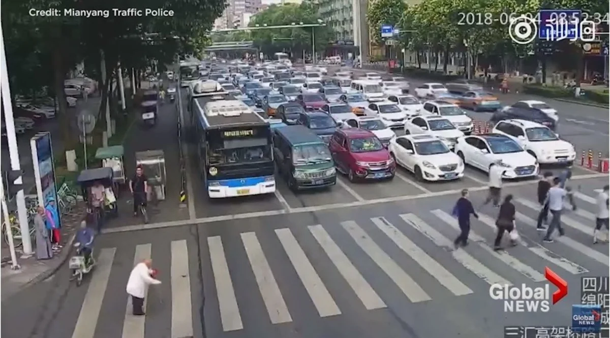 Китайский полицейский перенес пожилого прохожего через дорогу - ВИДЕО