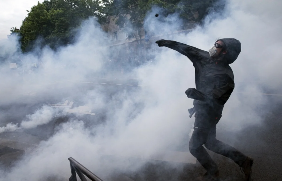 Protesters burn a police car in Paris