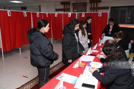 Head of polling station notes voter activity at polling station No. 10 of Khatai Third Constituency No. 35