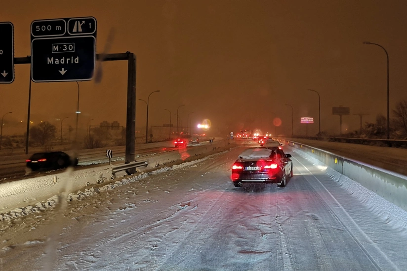 Futbolçular qarda qalan avtomobili itələdilər