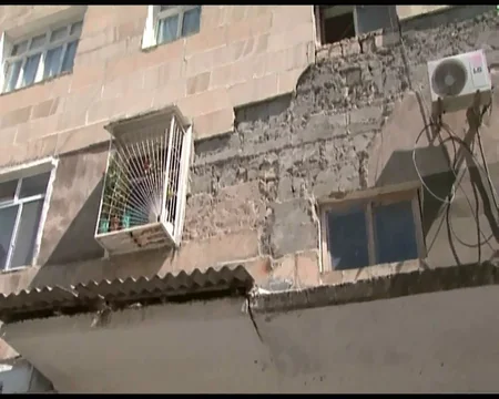 Göyçayın mərkəzində binanın fasadının daşları yerə tökülür: sakinlər təhlükə ilə üzləşib