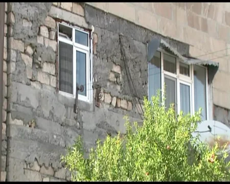Göyçayın mərkəzində binanın fasadının daşları yerə tökülür: sakinlər təhlükə ilə üzləşib