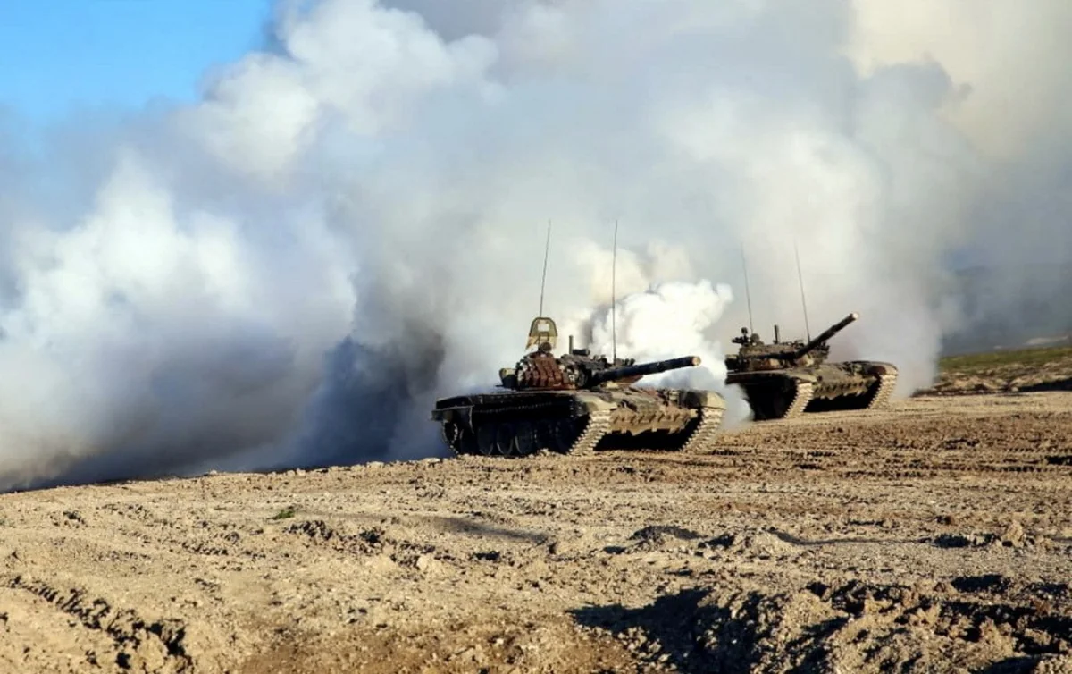 Zakir Hasanov watches live-fire training exercises at the combined-arms range